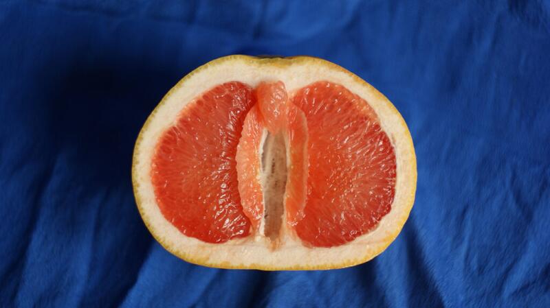 Half of a grapefruit against a blue background