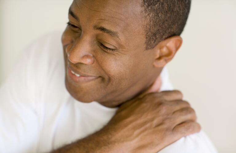 man holding aching shoulder