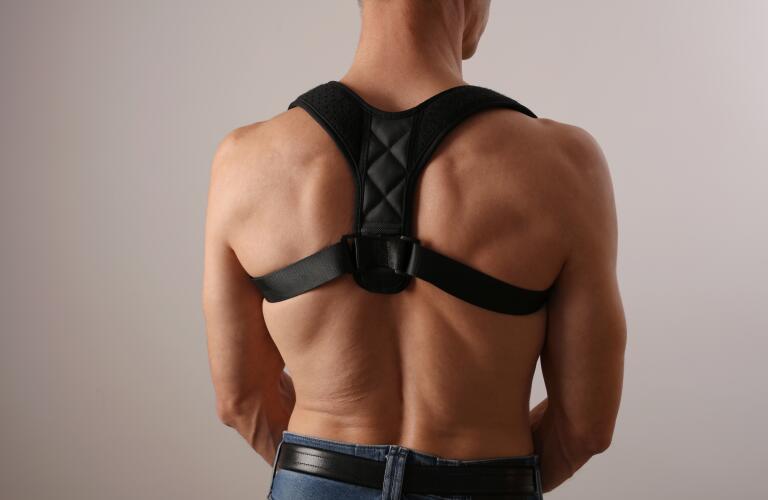Muscular man with posture corrector