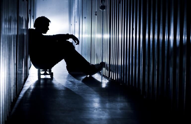 silhouette of someone in row of lockers or storage units