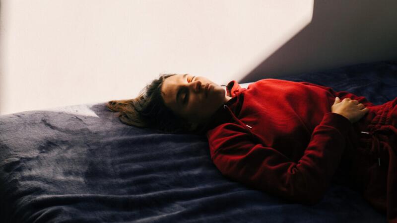 Woman laying down with her arm over her stomach