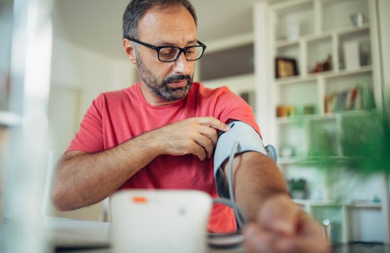 man checking blood pressure at home