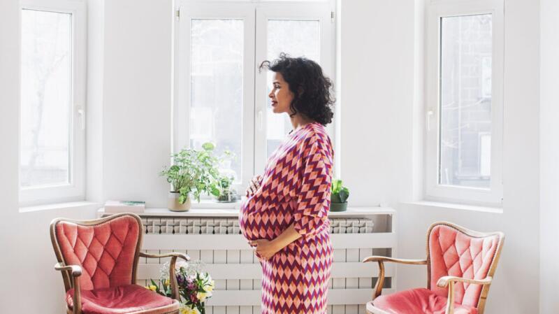 Pregnant woman standing by the window