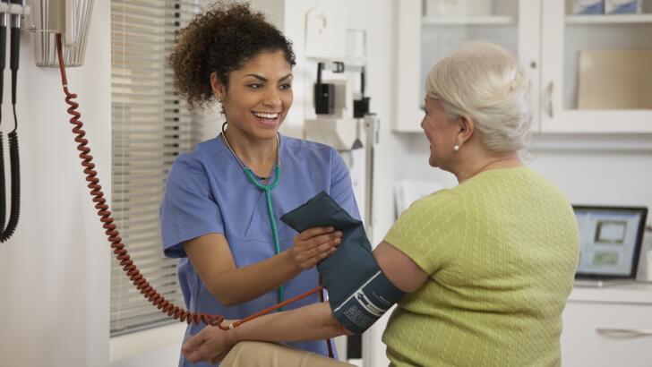 Nurse taking woman's blood pressure