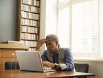 senior African American man sitting in office study looking at laptop