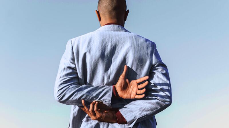A person has their hands behind their back.