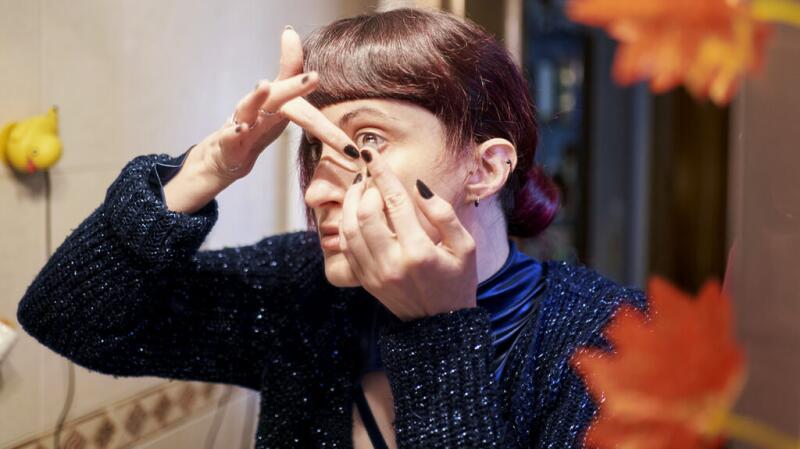 a woman is putting contact lenses in her eye