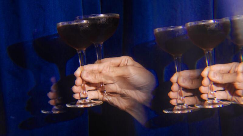 double vision of hand holding drink