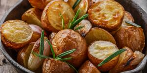 Baked potatoes in a pan with rosemary