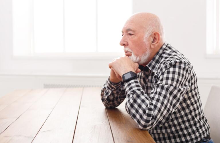 concerned senior man sitting at table