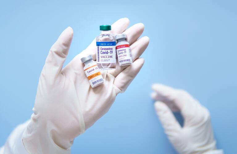 Close-up of potential Covid-19 vaccines in vials in scientist's hands during research and development in laboratory