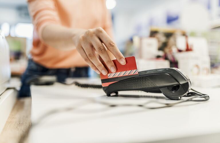 Close-up of Caucasian woman's hand swiping credit card