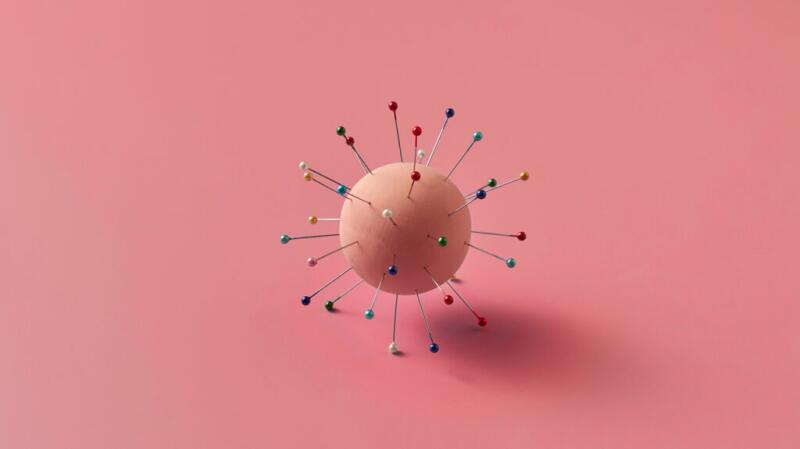 there is a needleball against a pink background