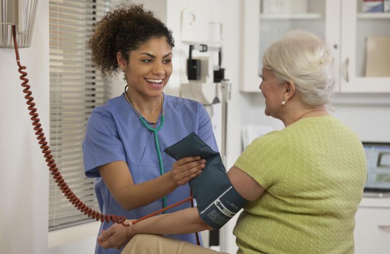 Nurse taking woman's blood pressure