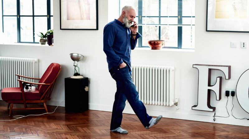 Man walking indoors while talking on the phone