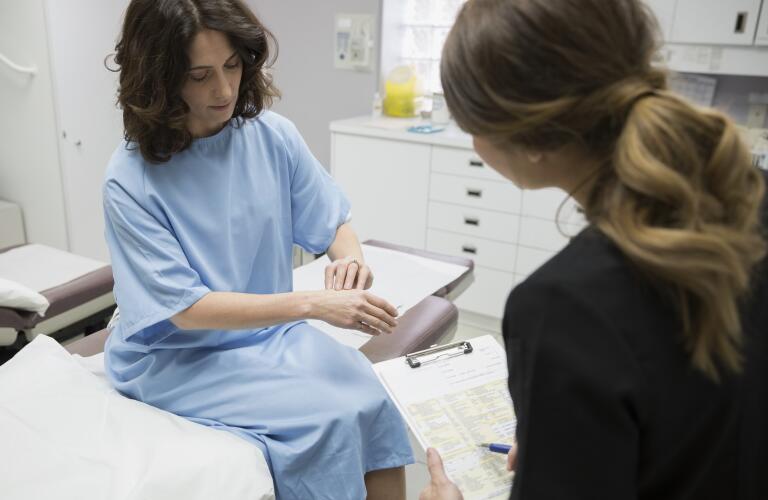 Female patient showing nurse hand in examination room