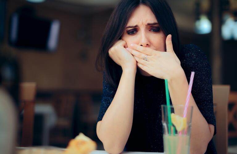 Nauseated Woman Feeling Sick at the Restaurant