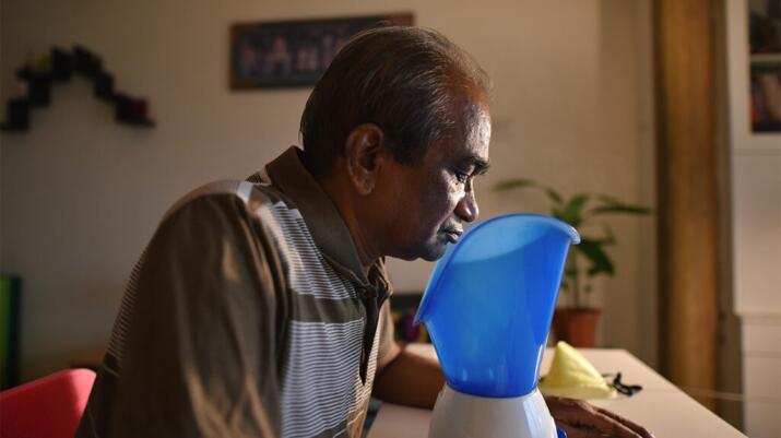 Older man using vaporizer or facial steamer