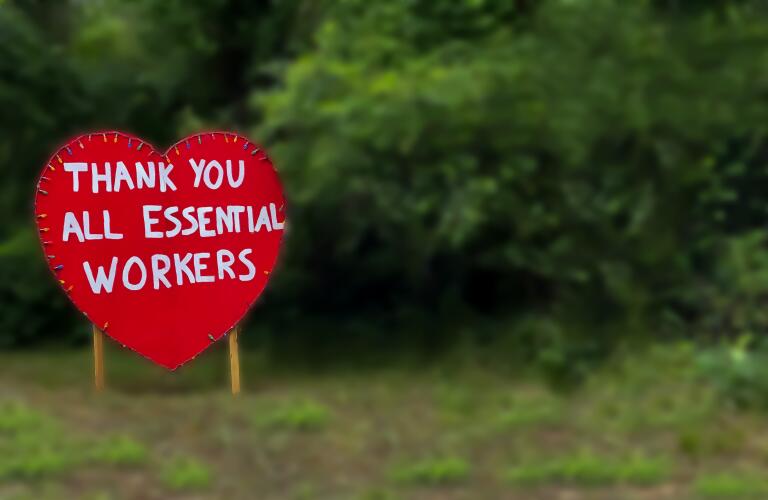 thank you sign to essential workers planted in grass