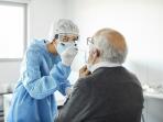Doctor taking swab test sample of elderly patient, PCR.