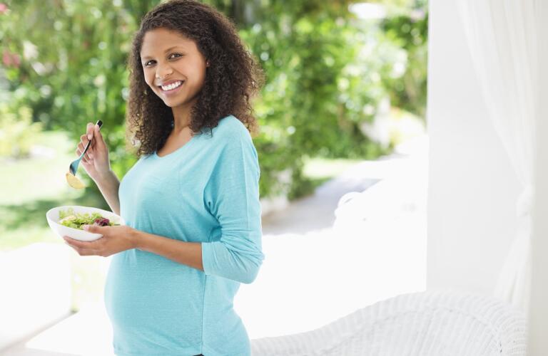 Pregnant woman eating salad