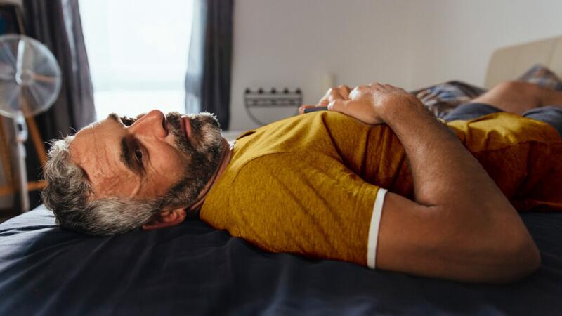 A man laying on his back with his hands on his stomach