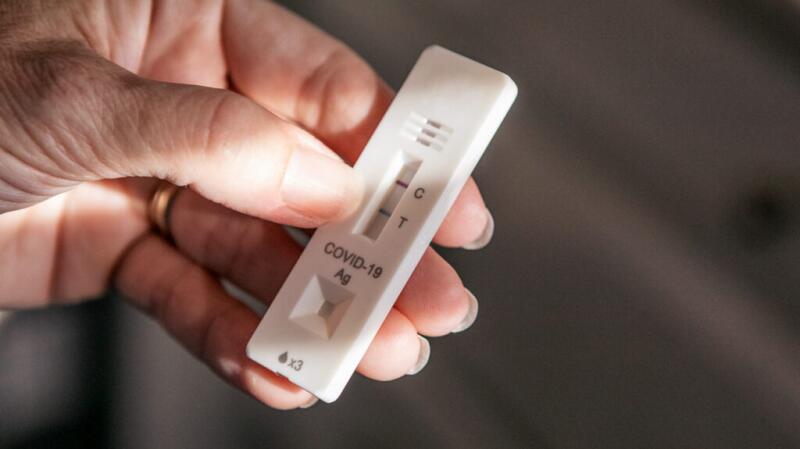 hand holding positive covid-19 rapid antigen test