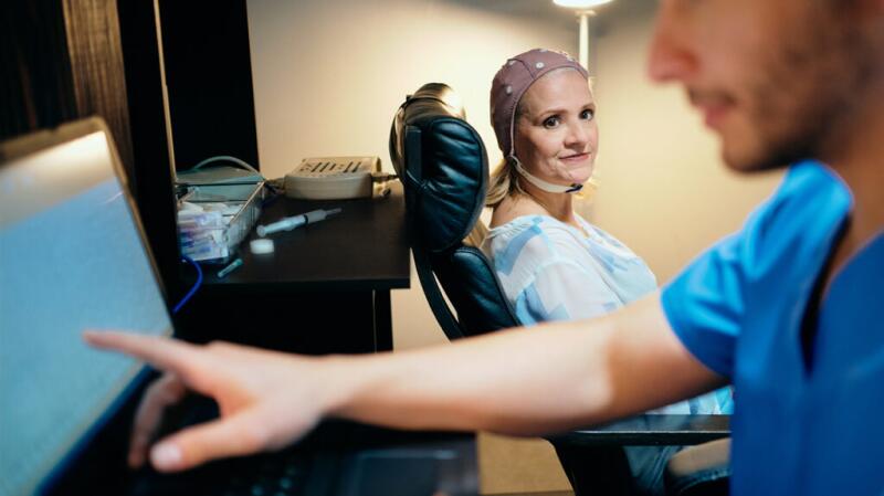 Doctor performing an EEG on a woman