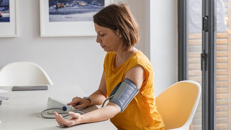 a woman is checking her blood pressure