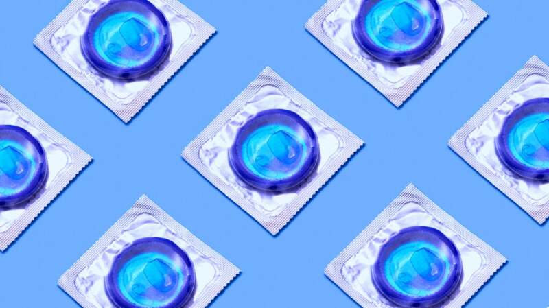 Packets of blue condoms rest on a plain blue background.