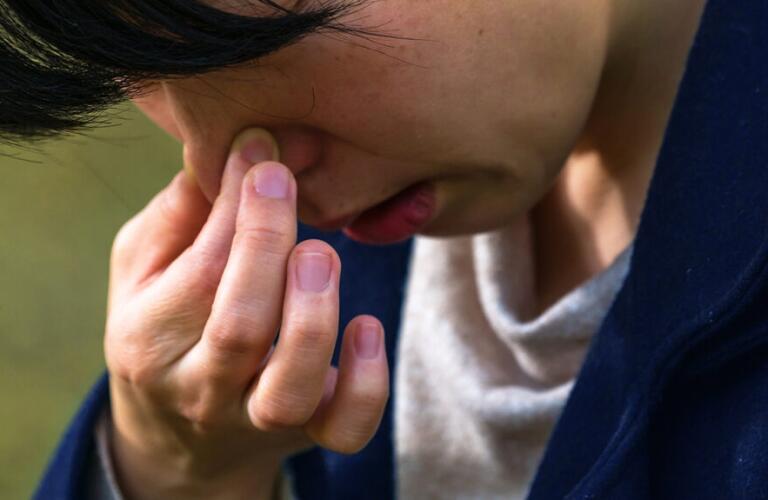 a woman is pinching her nose to do the reverse valsalva maneuver