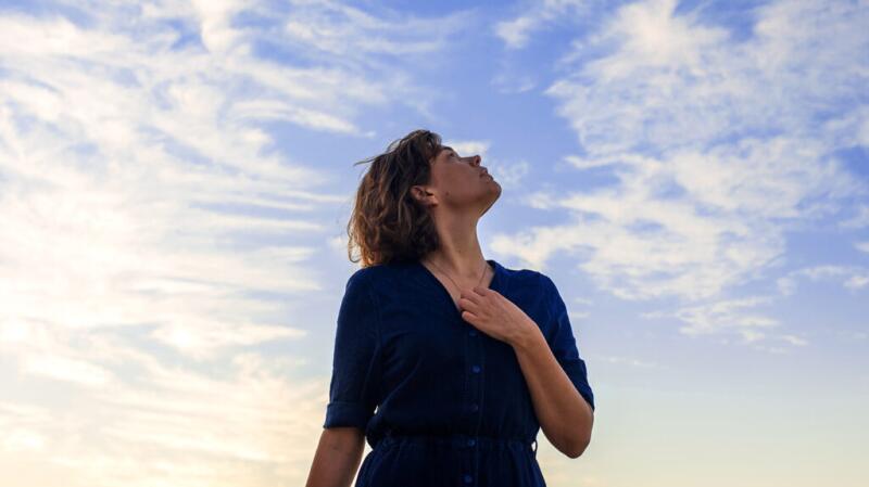a woman is having heart palpitations and is staring at the sky