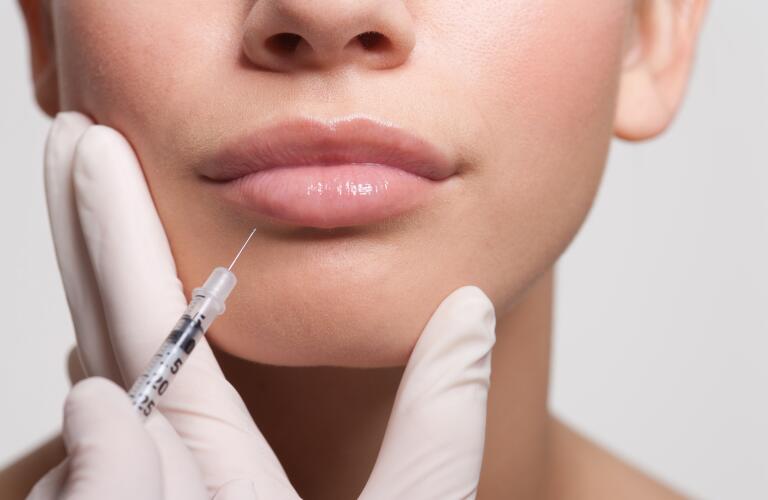 Close up of woman receiving injection in lips