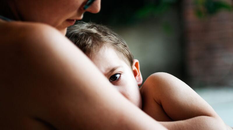 Mom holding young child who is sick