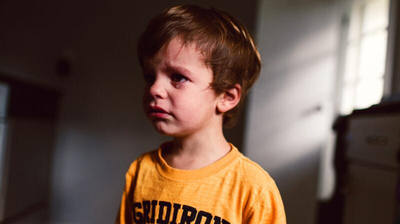 A child looks upset and tearful