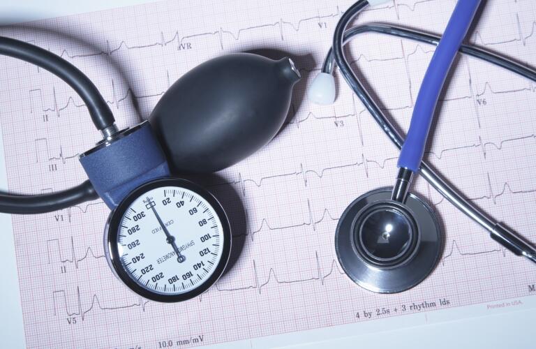 Acoustic stethoscope and blood pressure gauge on an electrocardiogram printout