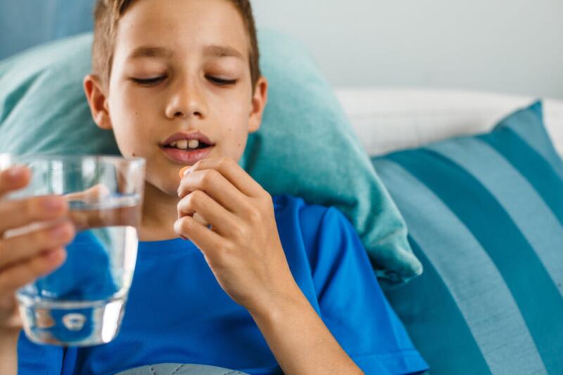 Teenage boy taking medicine