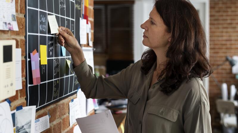 woman using sticky notes to organize a calendar