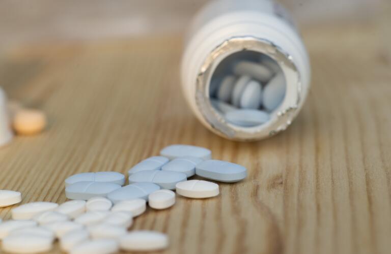 bottle of PrEP HIV pills spilling on table near additional pills