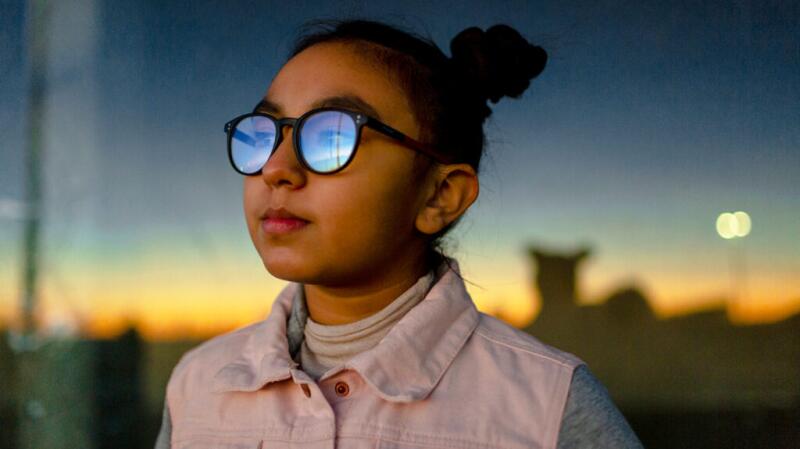 light reflecting on glasses a girl is wearing