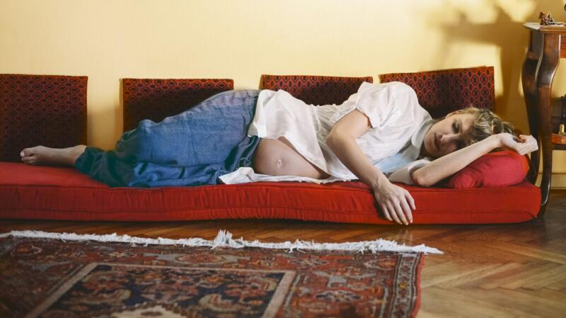 Pregnant woman lying on her side on couch