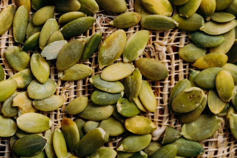 A close-up of pumpkin seeds on a burlap bag.