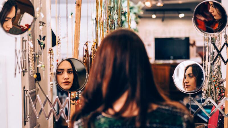 Female studying her reflection in multiple mirrors