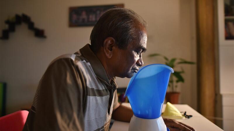 Older man using vaporizer or facial steamer