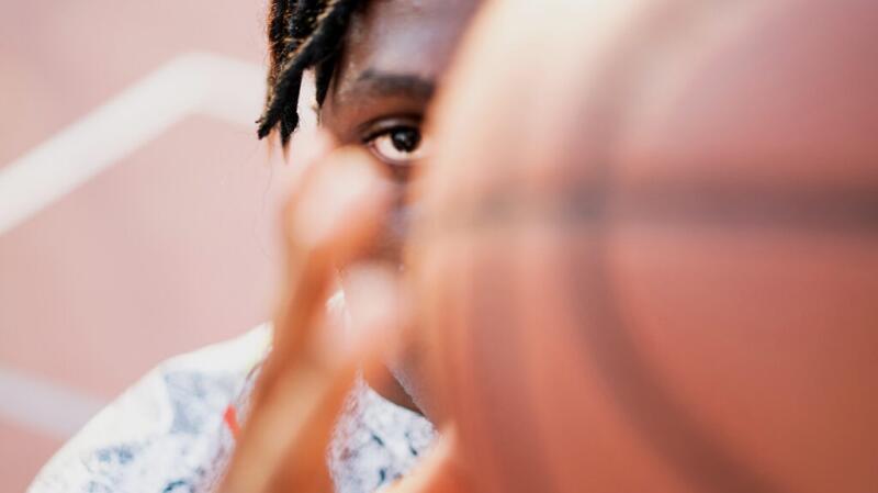 There is a closeup of a person holding a basketball.