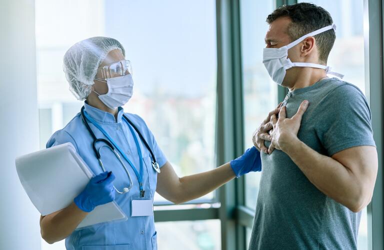 Female doctor talking to patient who is complaining of chest pain at medical clinic