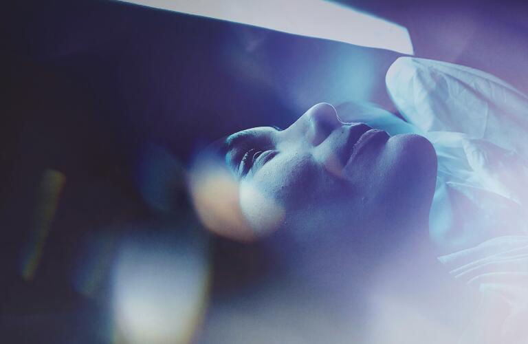 Close-Up Of Woman Sleeping On Bed with Blue Light Filter
