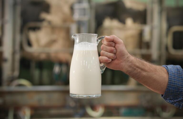 man-holding-out-pitcher-of-milk