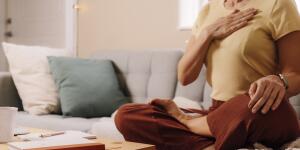 unidentifiable woman indoors relaxing, meditating and doing breathing exercises 