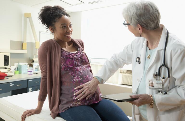Young African American pregnant woman getting exam with ob/gyn